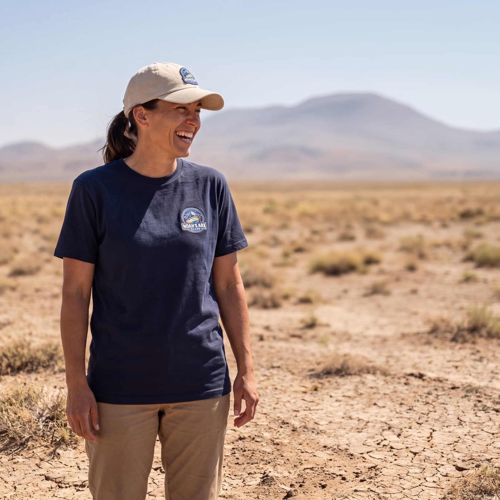 A supporter wearing the Noah's Ark Scans tee and cap on open, dry terrain